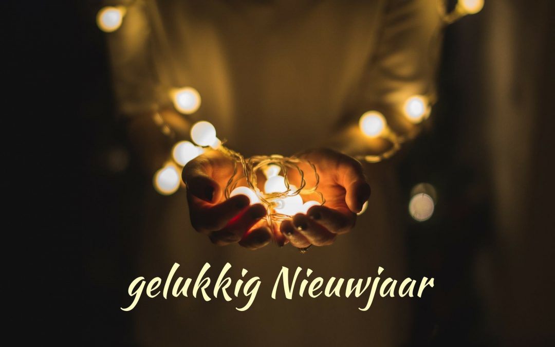 • twee handen in een kommetje die een lichtjeskrans lijken aan te bieden - tekst op de foto: gelukkig Nieuwjaar